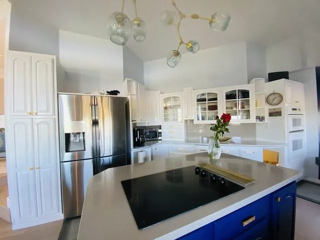a kitchen with granite countertop a refrigerator a stove and a sink