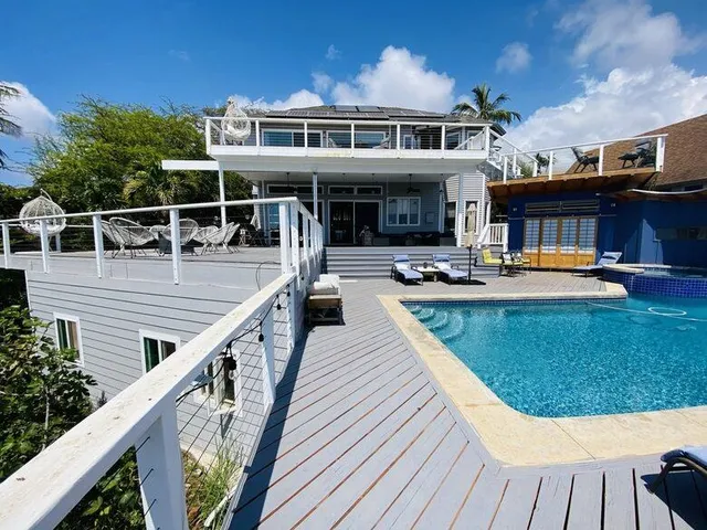 a view of a house with pool and chairs