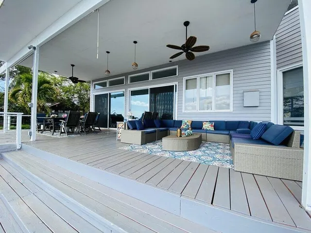 a view of a patio with table and chairs couches wooden floor and a table