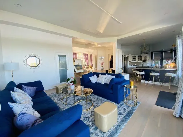 a living room with furniture and kitchen view