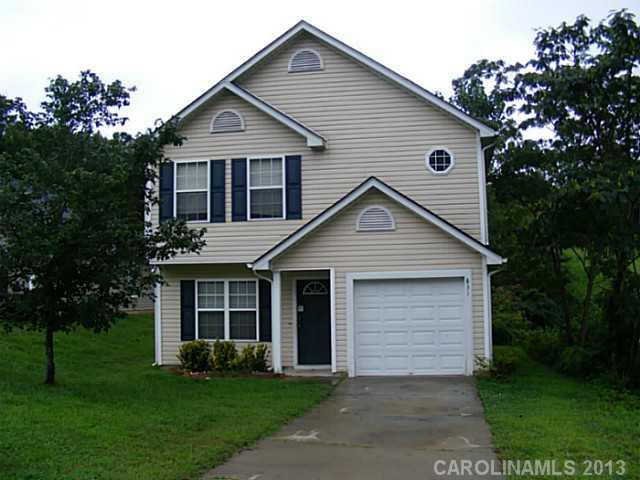 a front view of a house with a garden and yard