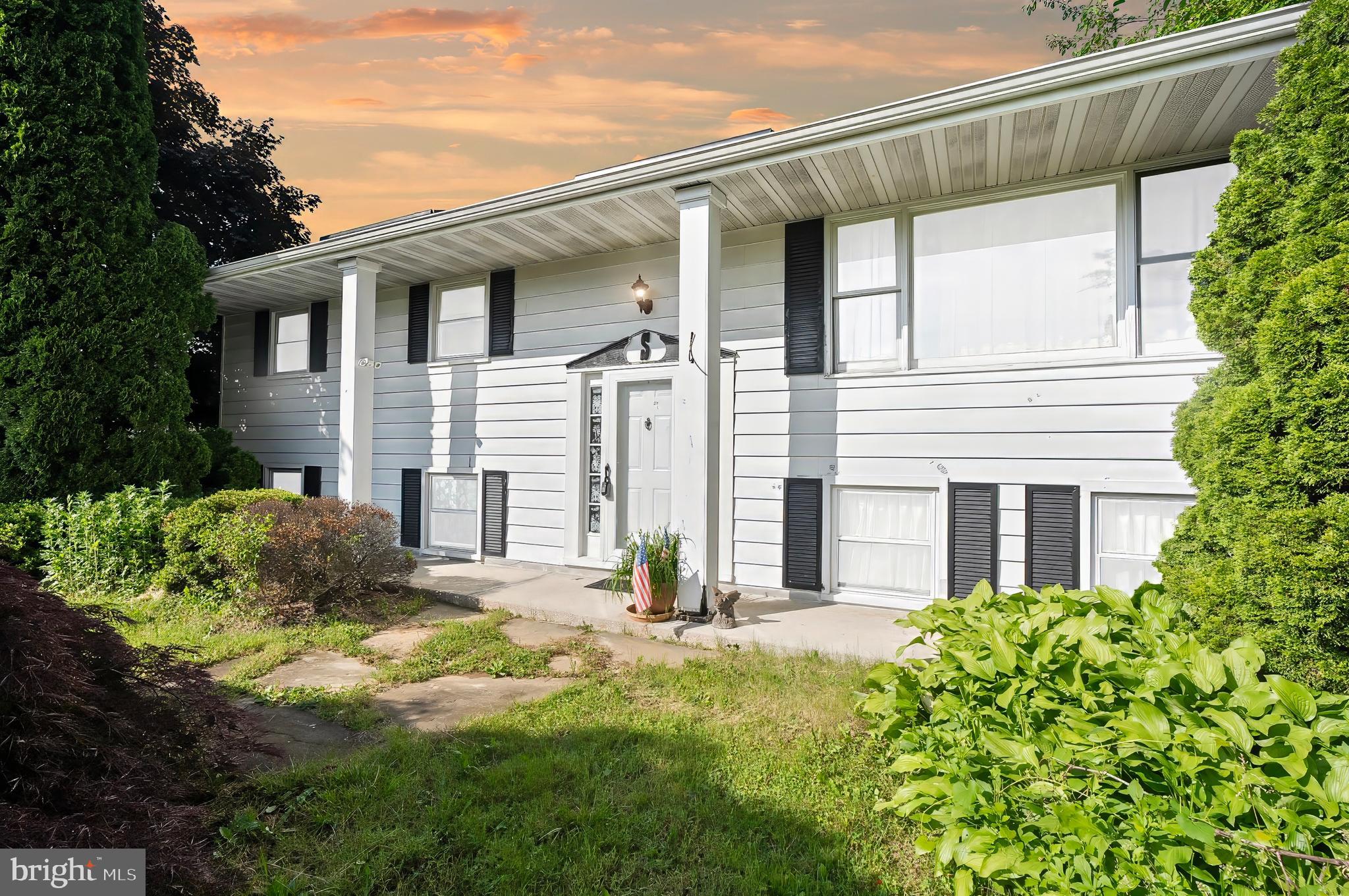 1715 Walker Road Freeland, MD 21053 - Photo 1 of 31 a backyard of a white house with potted plants and a large tree