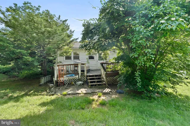 a view of a house with a yard deck and a small cabin