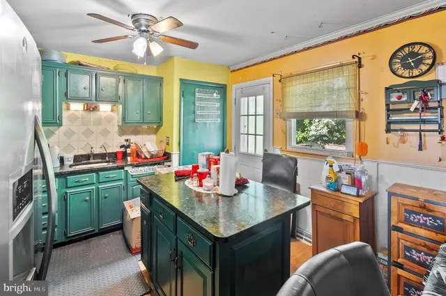 a kitchen with a stove a sink dishwasher and a dining table with the kitchen view