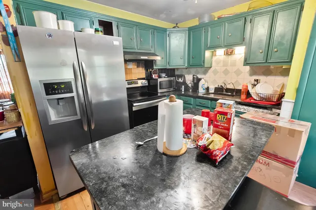 a kitchen with stainless steel appliances granite countertop a refrigerator and a stove top oven