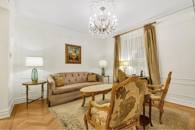 a living room with furniture and a chandelier