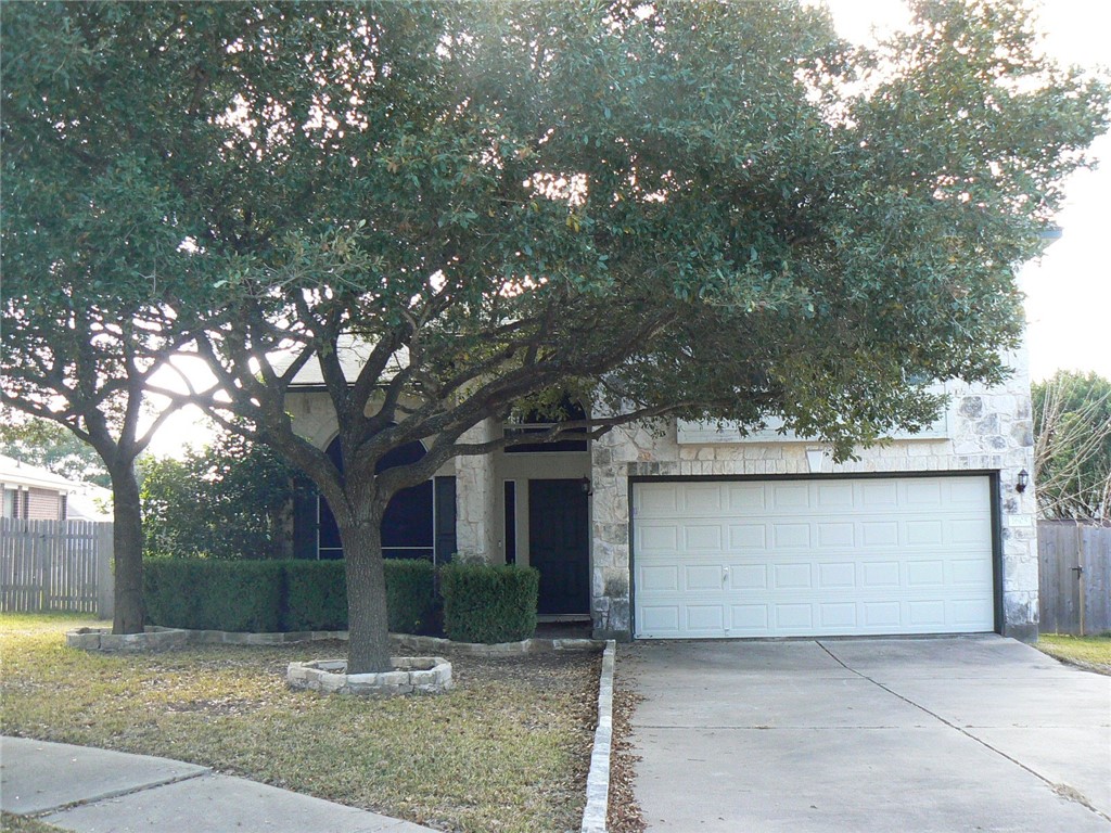 front view of a house with a yard and an trees