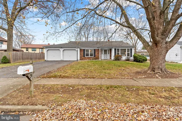 a front view of a house with a yard and trees