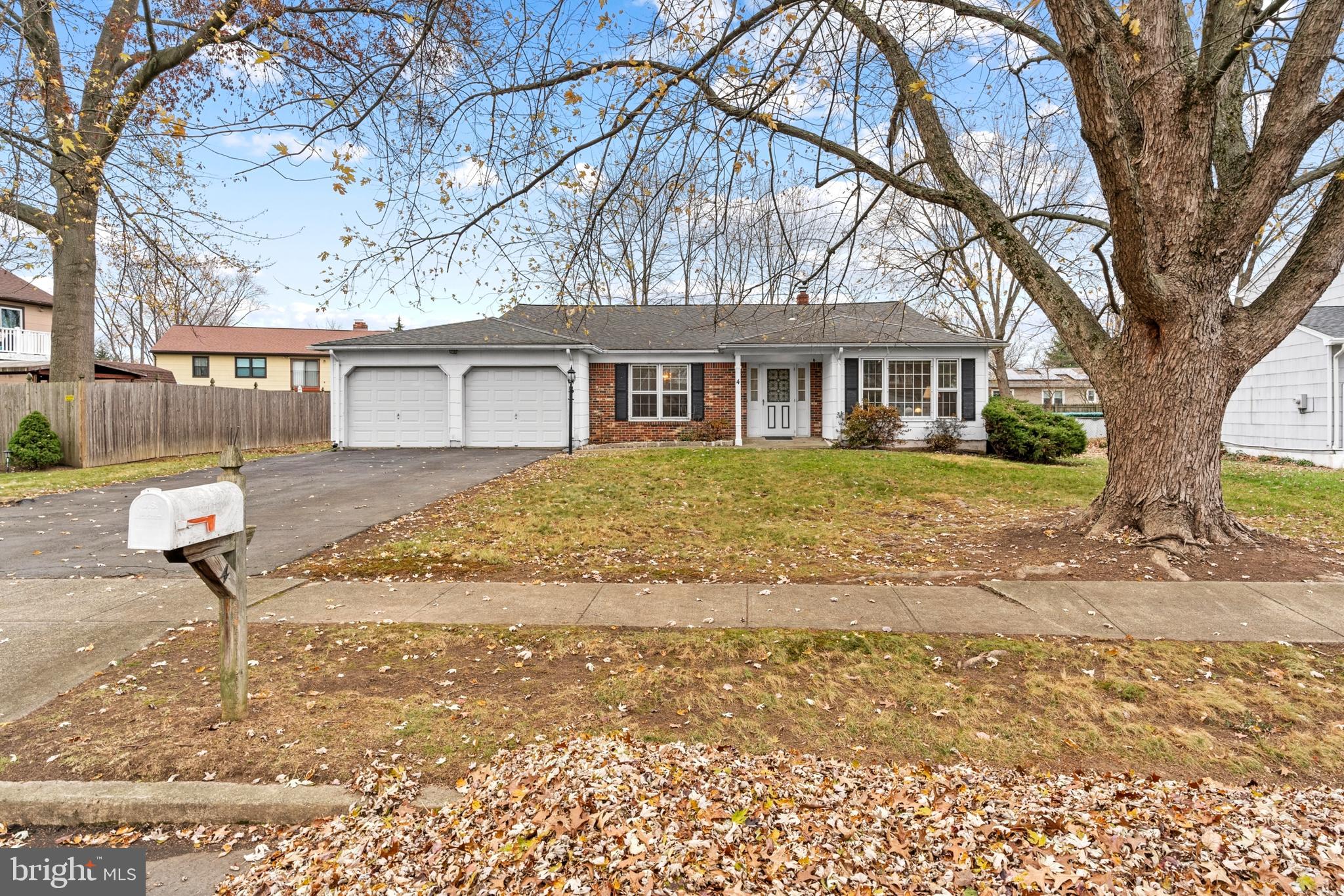 a front view of a house with a yard and trees