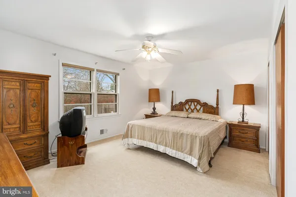 a bedroom with a bed flat screen tv and window