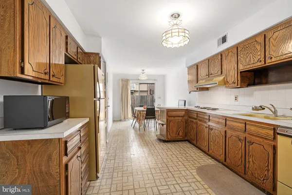 a kitchen with stainless steel appliances granite countertop a stove a sink dishwasher and a microwave oven with white cabinets