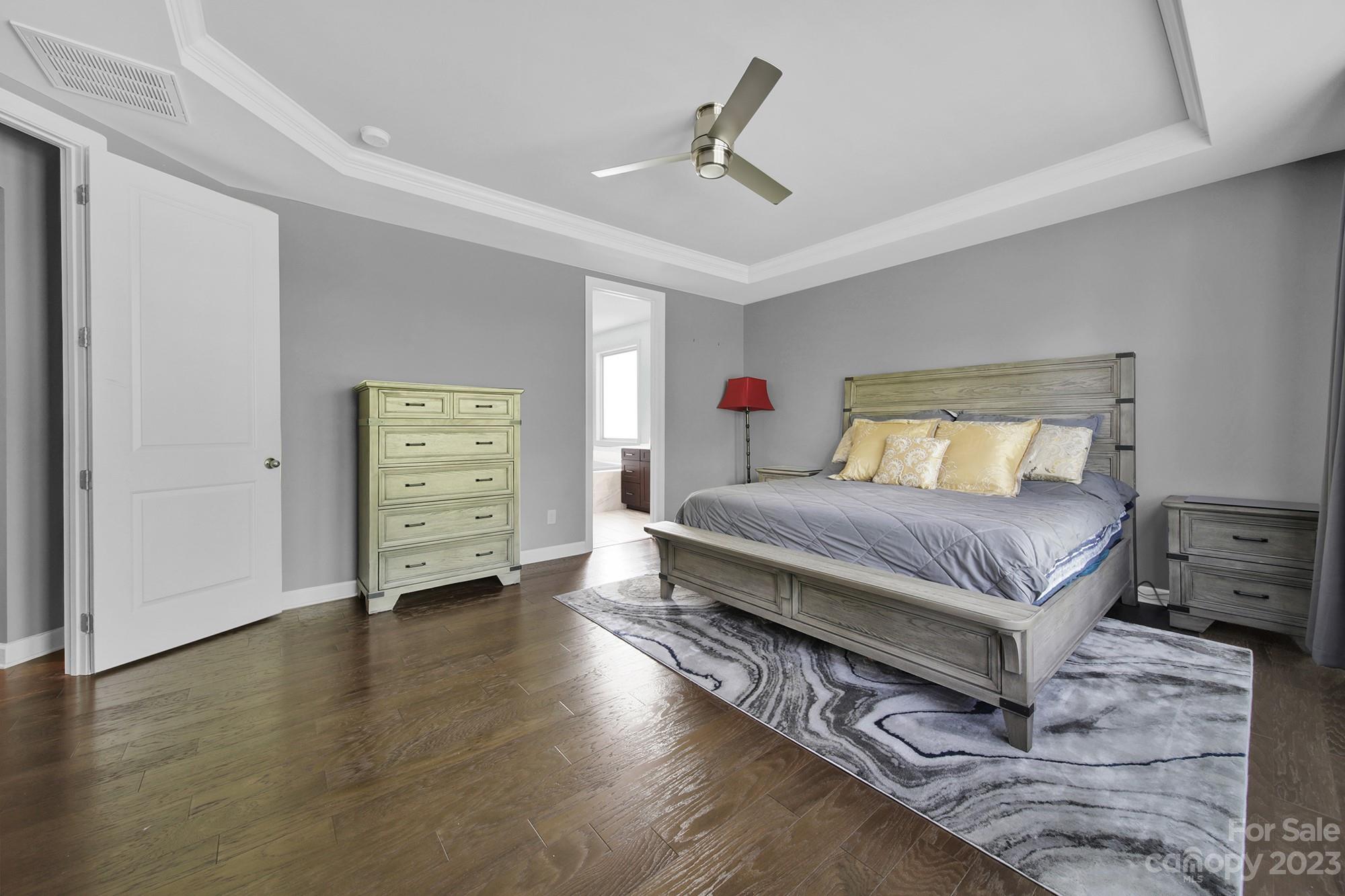 1516 Hazel Street Tega Cay, SC 29708 - Photo 28 of 48 a spacious bedroom with a bed and a chandelier