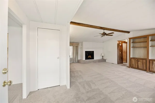 a view of an empty room with a fireplace and a window