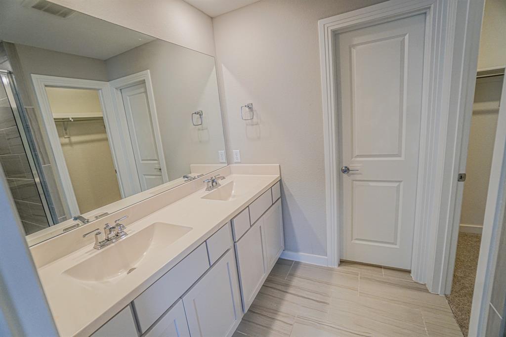 1309 Old Rocksprings Pass Mansfield, TX 76063 - Photo 25 of 36 Bathroom featuring a dual vanity with integrated sinks, chrome fixtures, and a large wall-mounted mirror