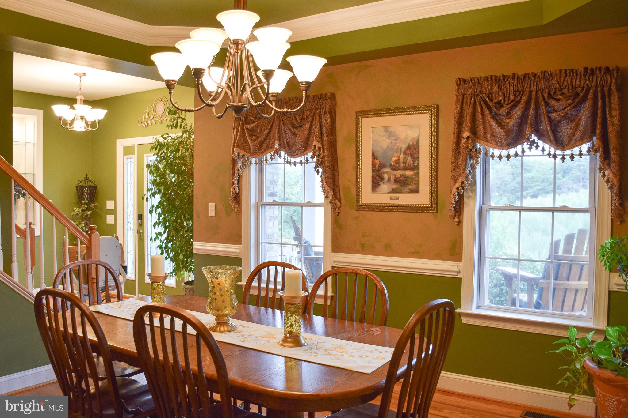 765 Gun Club Road Stephenson, VA 22656 - Photo 18 of 113 a view of a dining room with furniture a chandelier and large windows