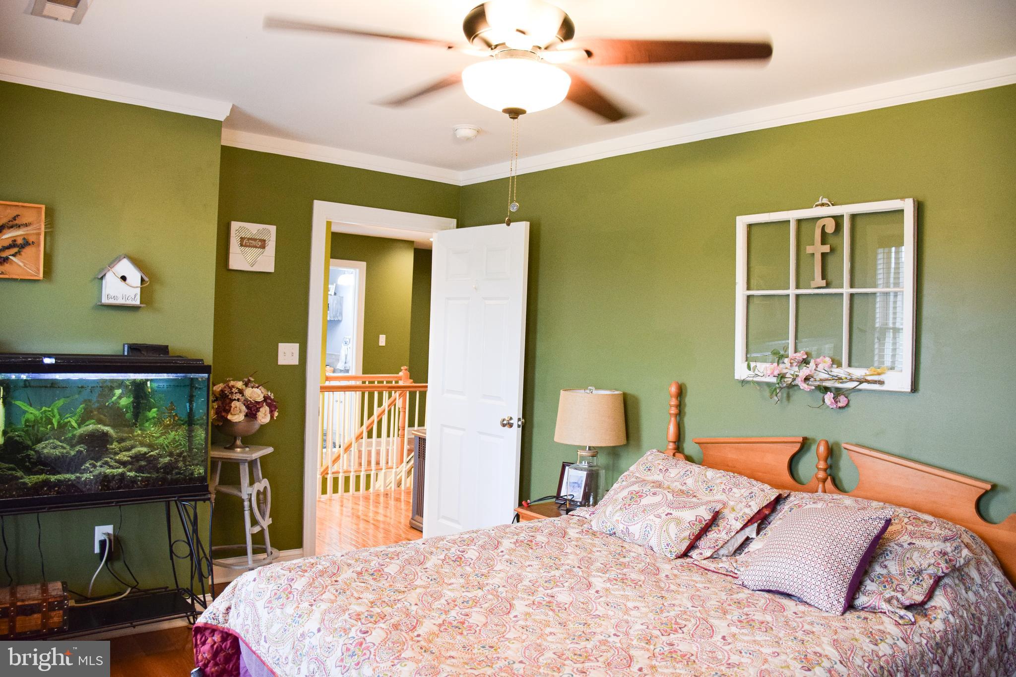 765 Gun Club Road Stephenson, VA 22656 - Photo 44 of 113 a bedroom with a bed and a chandelier