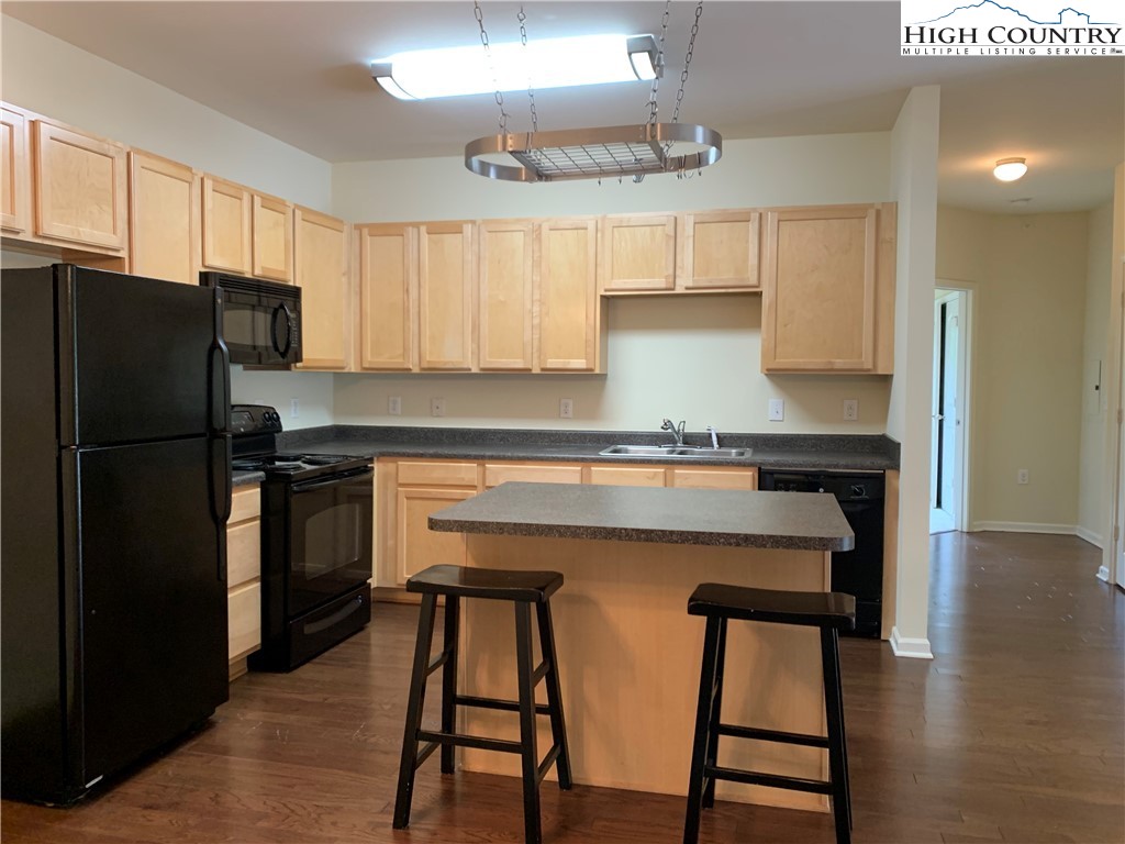 190 Eli Hartley Drive, Unit 210 Boone, NC 28607 - Photo 2 of 19 a kitchen with stainless steel appliances a refrigerator a sink a stove a table and chairs