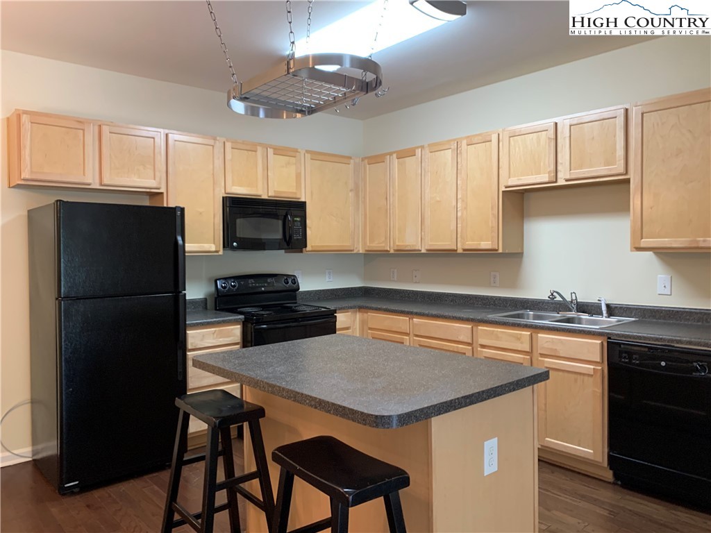 190 Eli Hartley Drive, Unit 210 Boone, NC 28607 - Photo 4 of 19 a kitchen with a center island and stainless steel appliances
