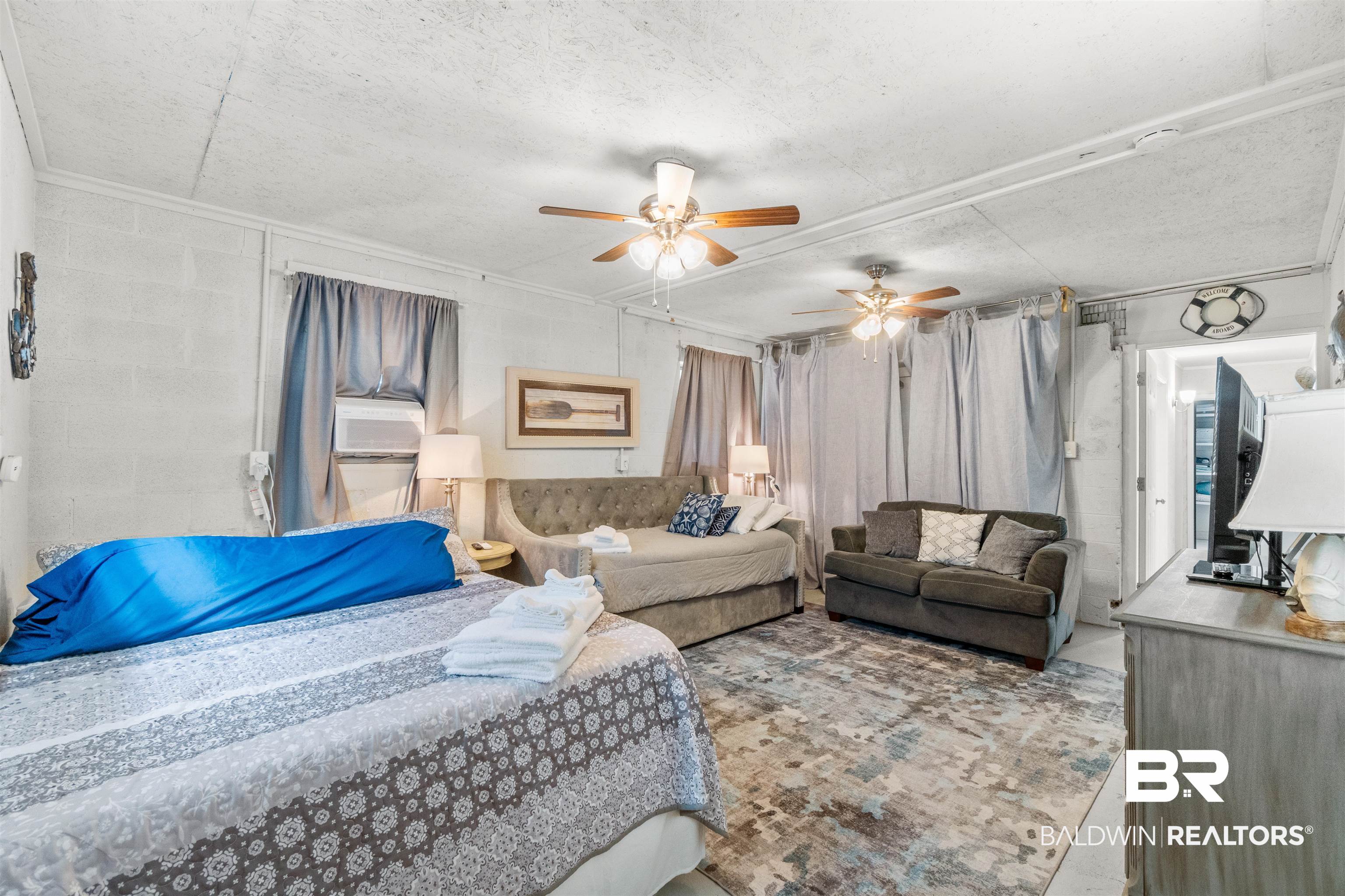 17595 River Road Summerdale, AL 36580 - Photo 17 of 29 Bedroom with a ceiling fan, concrete block wall, and a textured ceiling