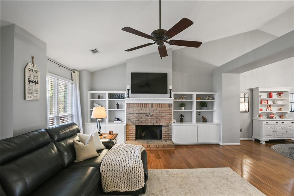 920 Bridge Pointe Court Alpharetta, GA 30005 - Photo 13 of 18 a living room with furniture a fireplace and a flat screen tv