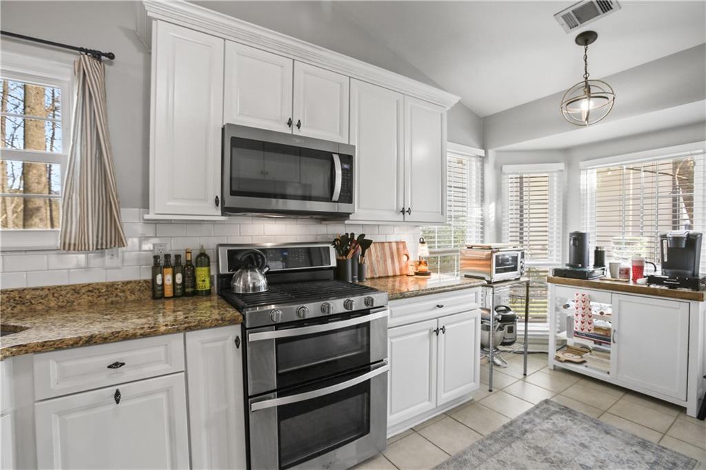 920 Bridge Pointe Court Alpharetta, GA 30005 - Photo 4 of 18 a kitchen with cabinets appliances a sink and a window