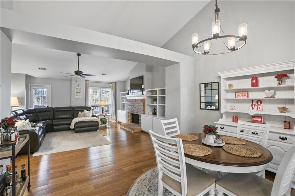 920 Bridge Pointe Court Alpharetta, GA 30005 - Photo 7 of 18 a living room with furniture and a dining table with wooden floor