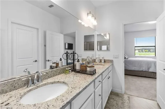 a bathroom with a granite countertop sink and a mirror