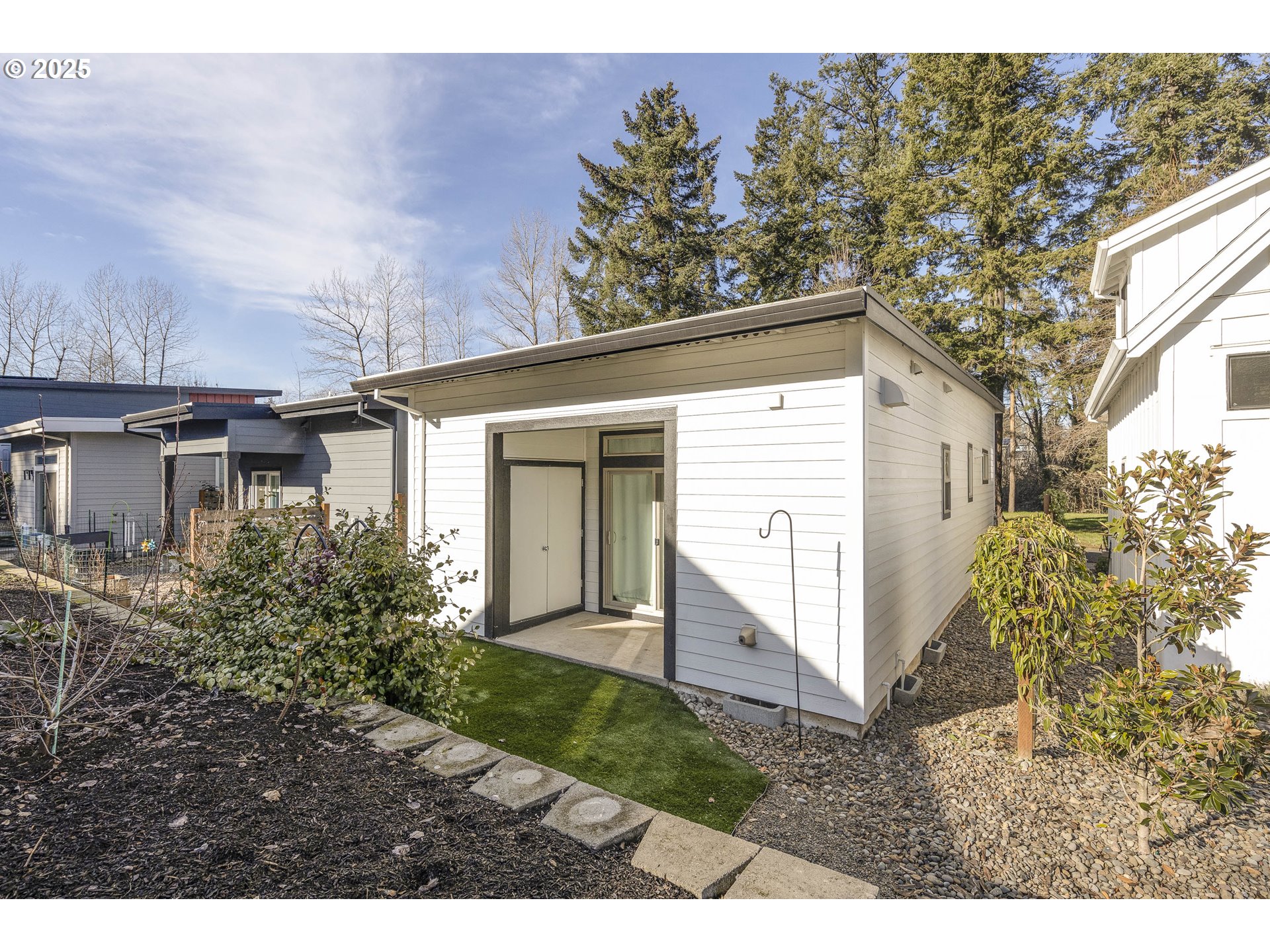 1821 Cousteau Loop Southeast Salem, OR 97302 - Photo 23 of 27 a view of a white house next to a yard with plants and trees