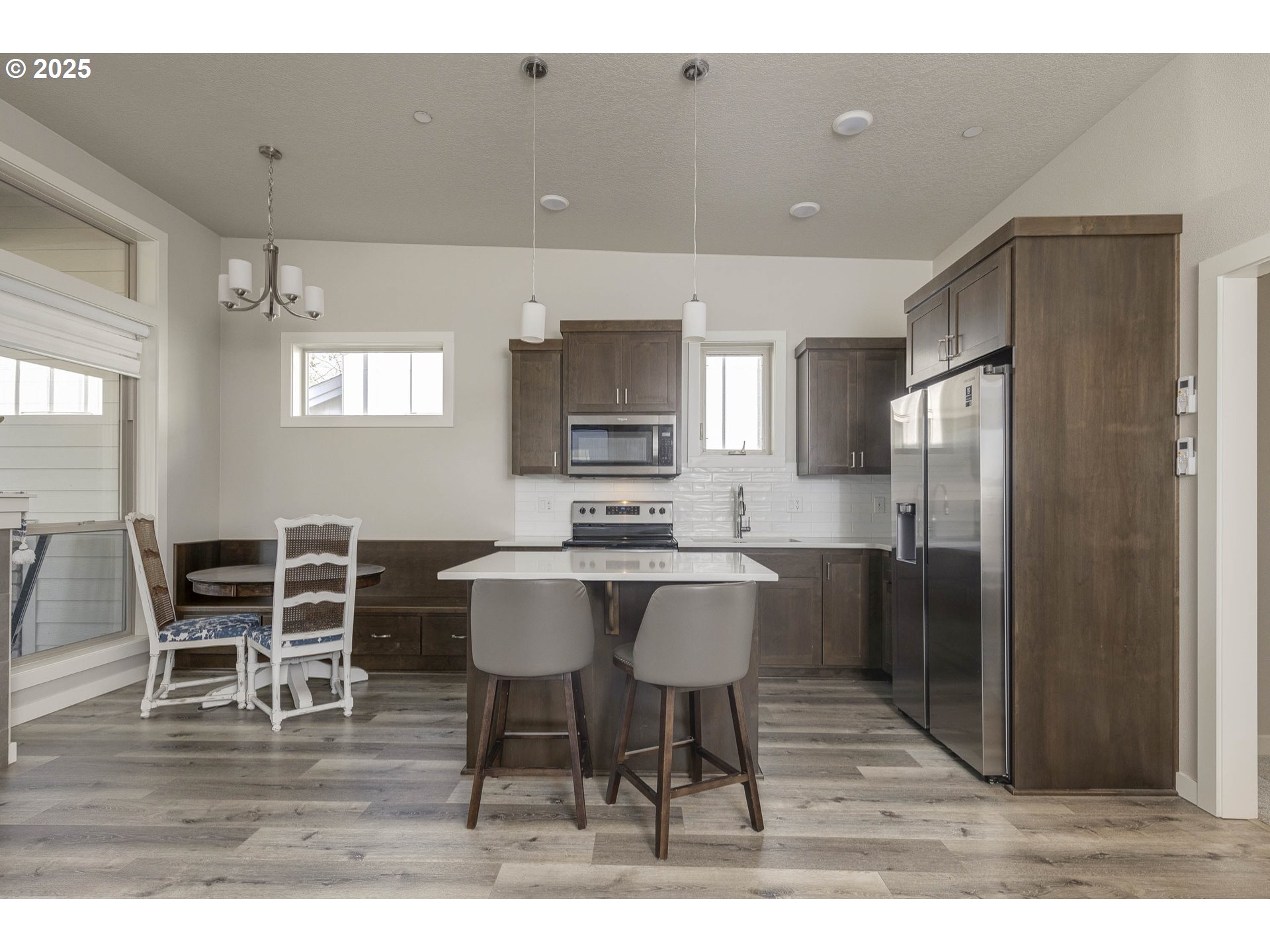1821 Cousteau Loop Southeast Salem, OR 97302 - Photo 9 of 27 a kitchen with stainless steel appliances kitchen island granite countertop a table chairs and a refrigerator