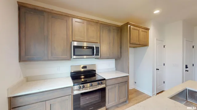 a kitchen with stainless steel appliances a stove a microwave and cabinets