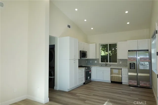a kitchen with stainless steel appliances a refrigerator and a stove top oven