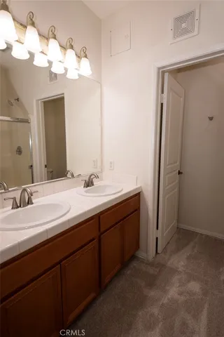 a bathroom with a double vanity sink and a mirror