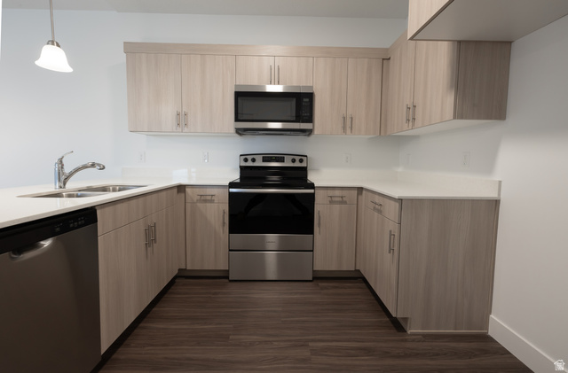 4653 South Alder Drive, Unit H302 Mapleton, UT 84664 - Photo 7 of 15 Kitchen featuring light wood finish cabinets, stainless steel appliances, pendant lighting, dark wood-style floors, and a peninsula