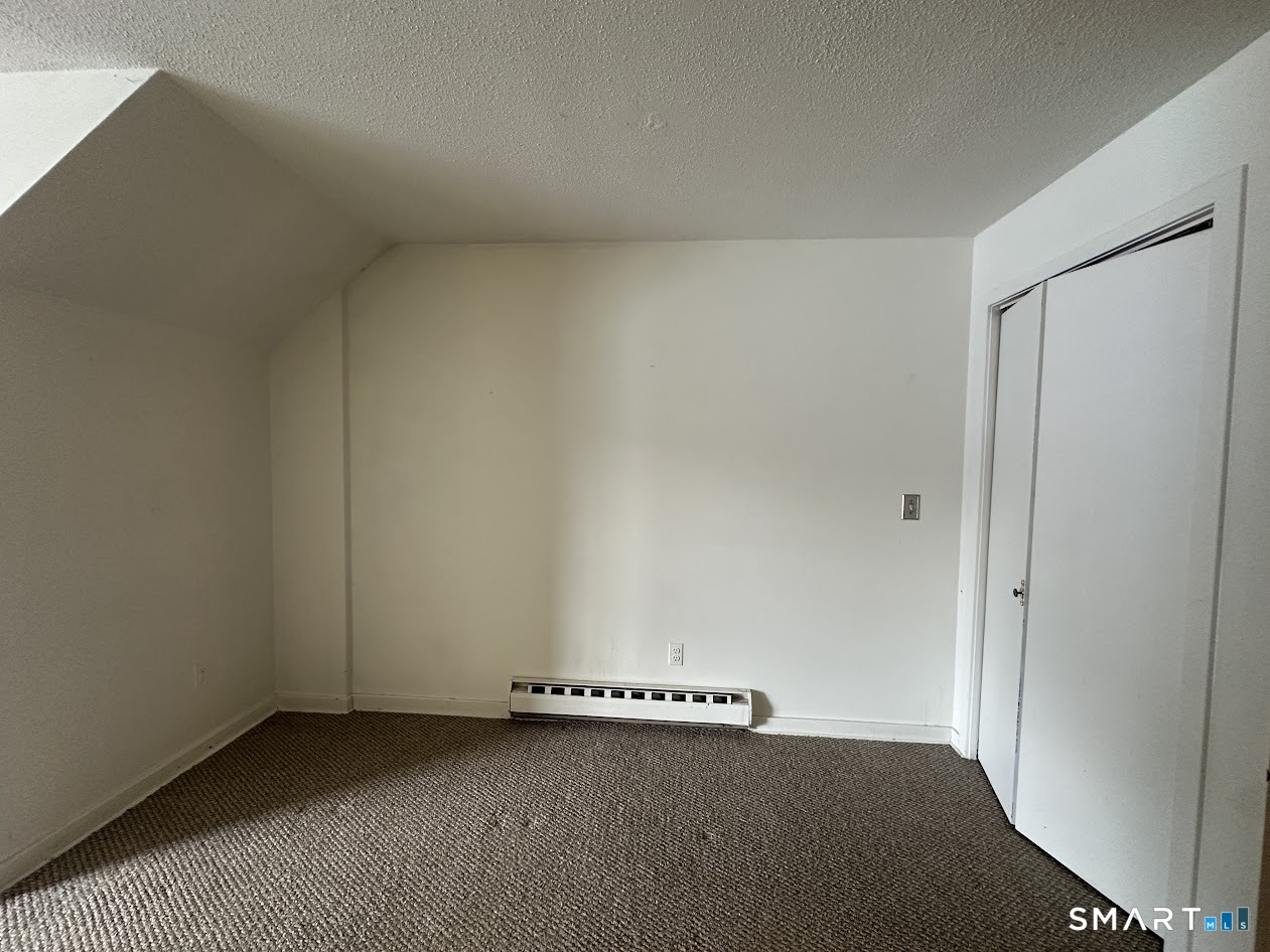 295 Redstone Hill Road, Unit 3 Bristol, CT 06010 - Photo 13 of 13 an empty room with a bench