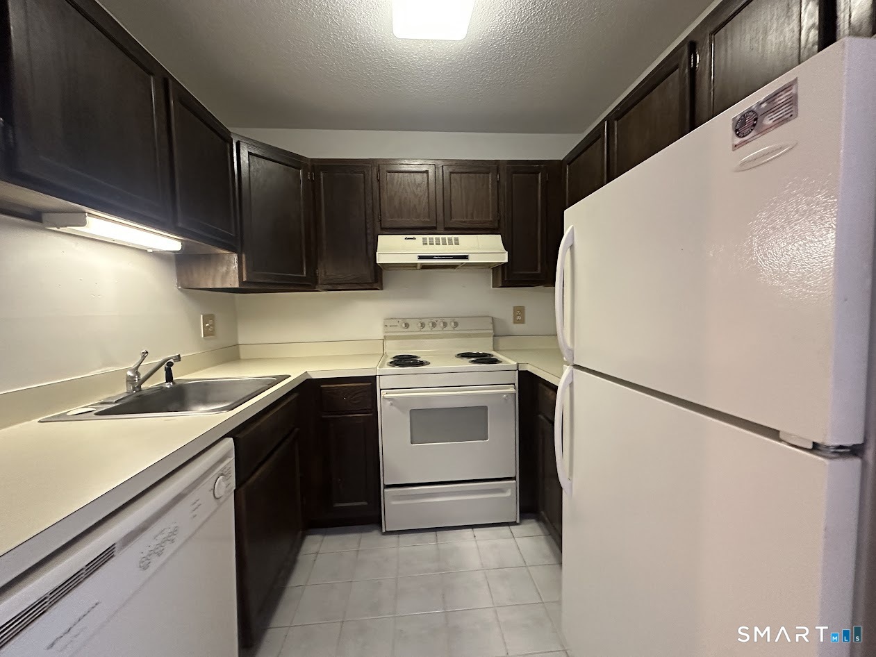 295 Redstone Hill Road, Unit 3 Bristol, CT 06010 - Photo 3 of 13 a kitchen with a white cabinets and white appliances