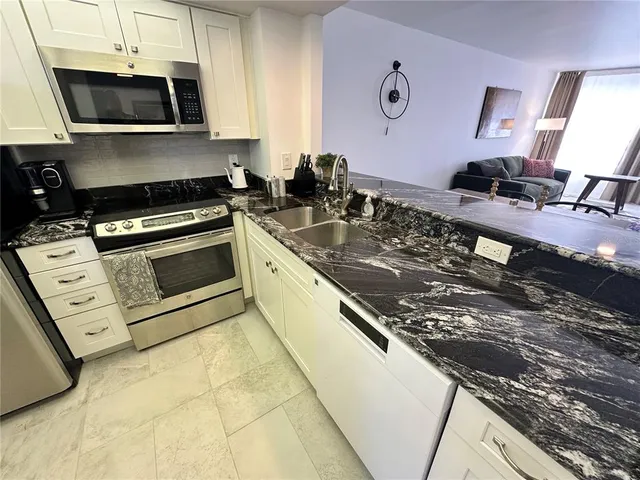a kitchen with stainless steel appliances granite countertop a sink stove and microwave