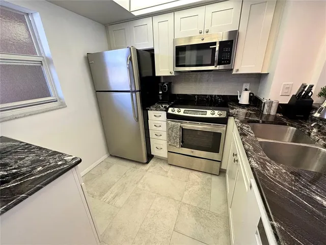 a kitchen with a sink and a mirror