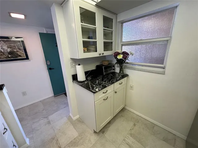 a kitchen with granite countertop a sink and cabinets