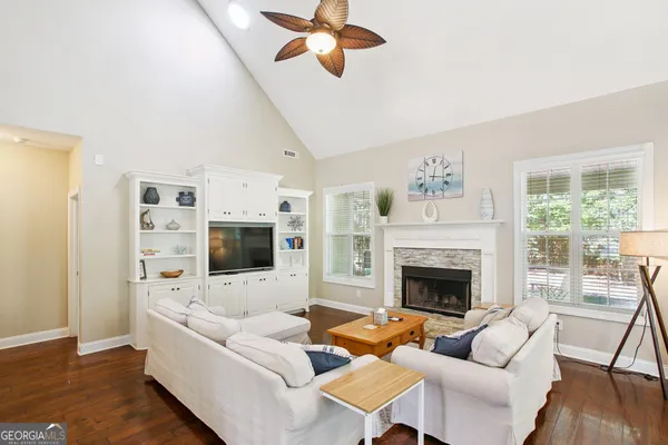 a living room with furniture kitchen view and a chandelier