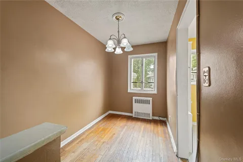 a view of a room with wooden flooring and ceiling fan
