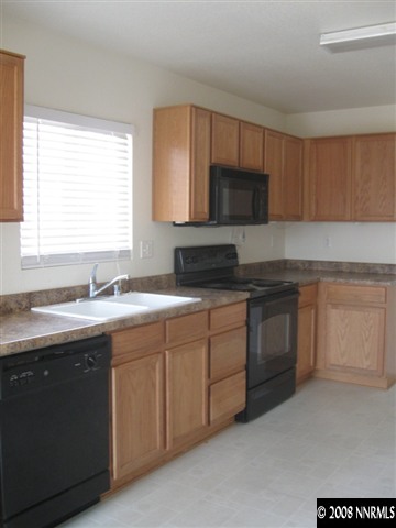 7623 Corso Street Reno, NV 89506 - Photo 3 of 7 a kitchen with a sink stove and microwave