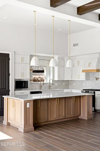 a kitchen with stainless steel appliances granite countertop a sink a stove and a microwave