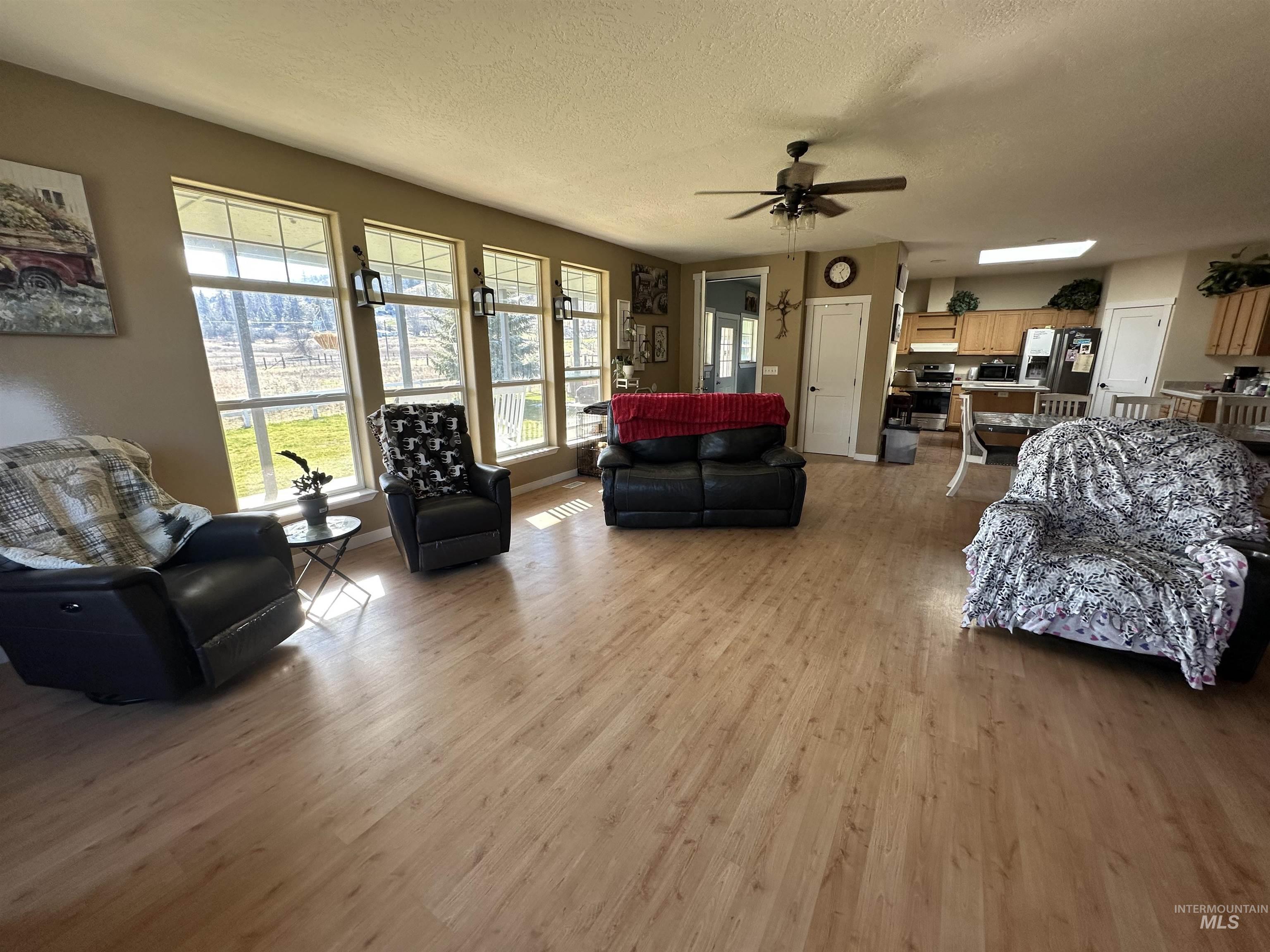 2859 Luke's Gulch Road Stites, ID 83552 - Photo 11 of 48 Living room with light wood-style flooring, a ceiling fan, and a textured ceiling