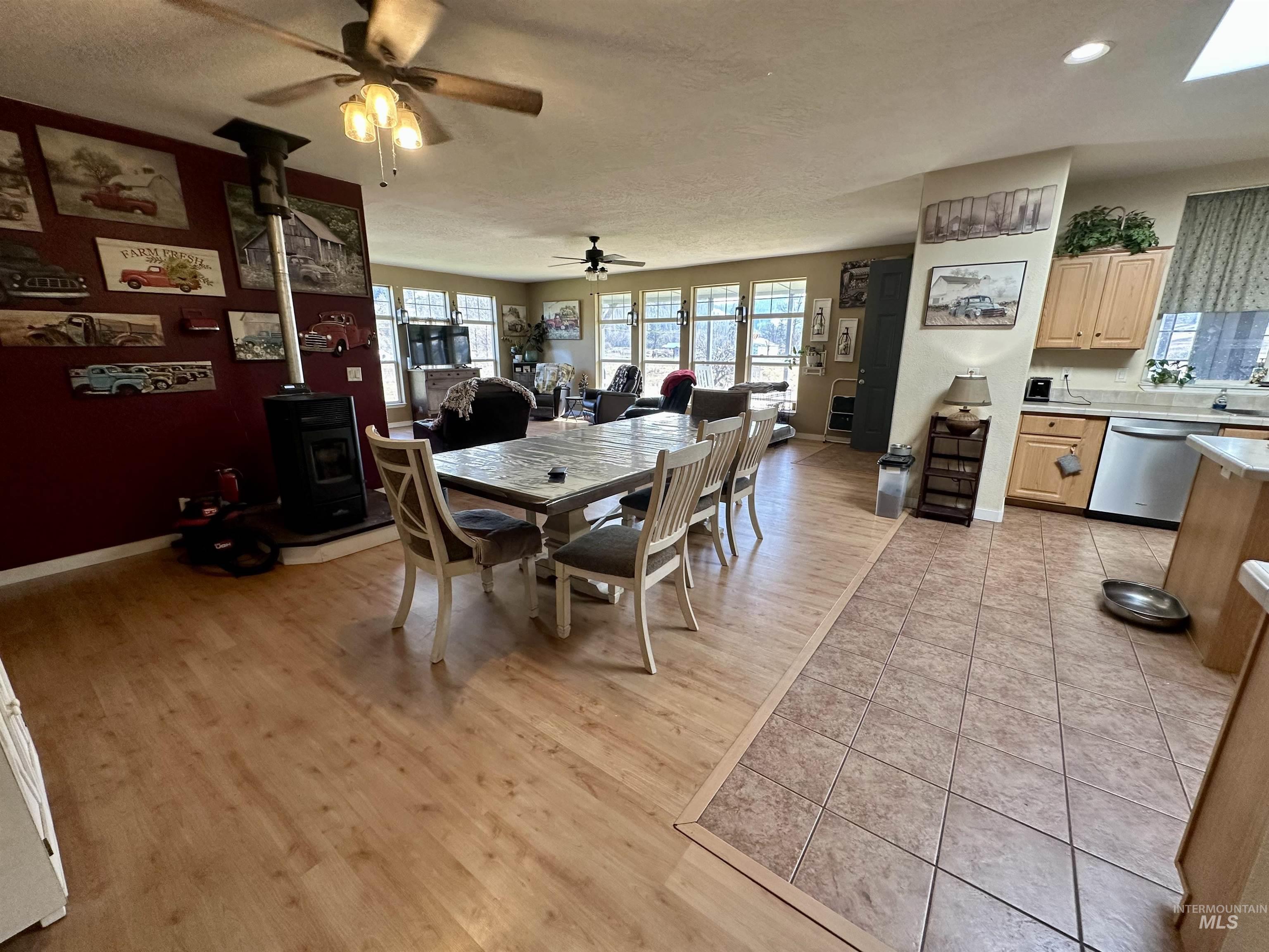 2859 Luke's Gulch Road Stites, ID 83552 - Photo 12 of 48 Dining room with a wood stove, light wood-type flooring, and ceiling fan