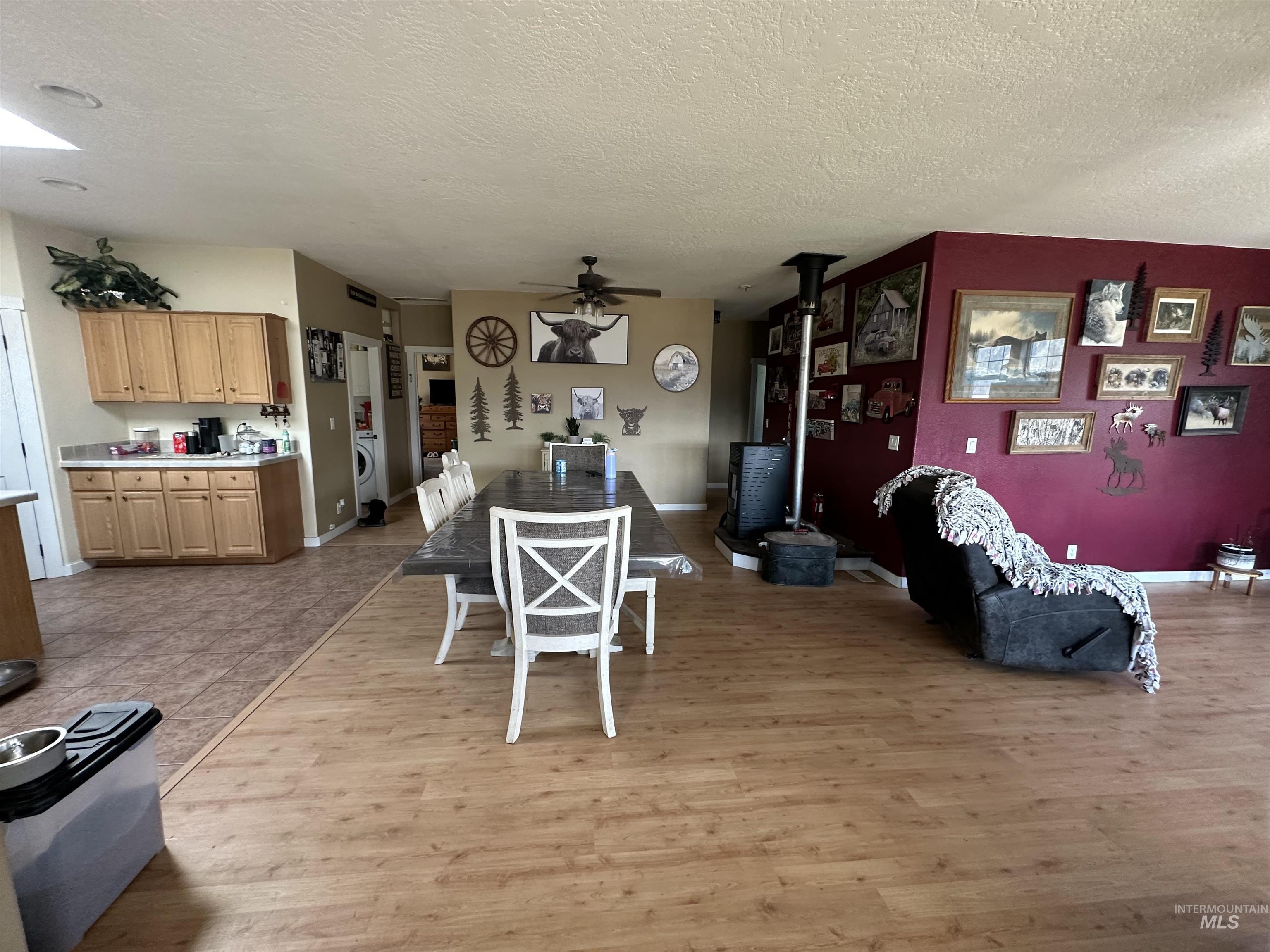 2859 Luke's Gulch Road Stites, ID 83552 - Photo 13 of 48 Dining area with a wood stove, light wood finished floors, ceiling fan, and a textured ceiling