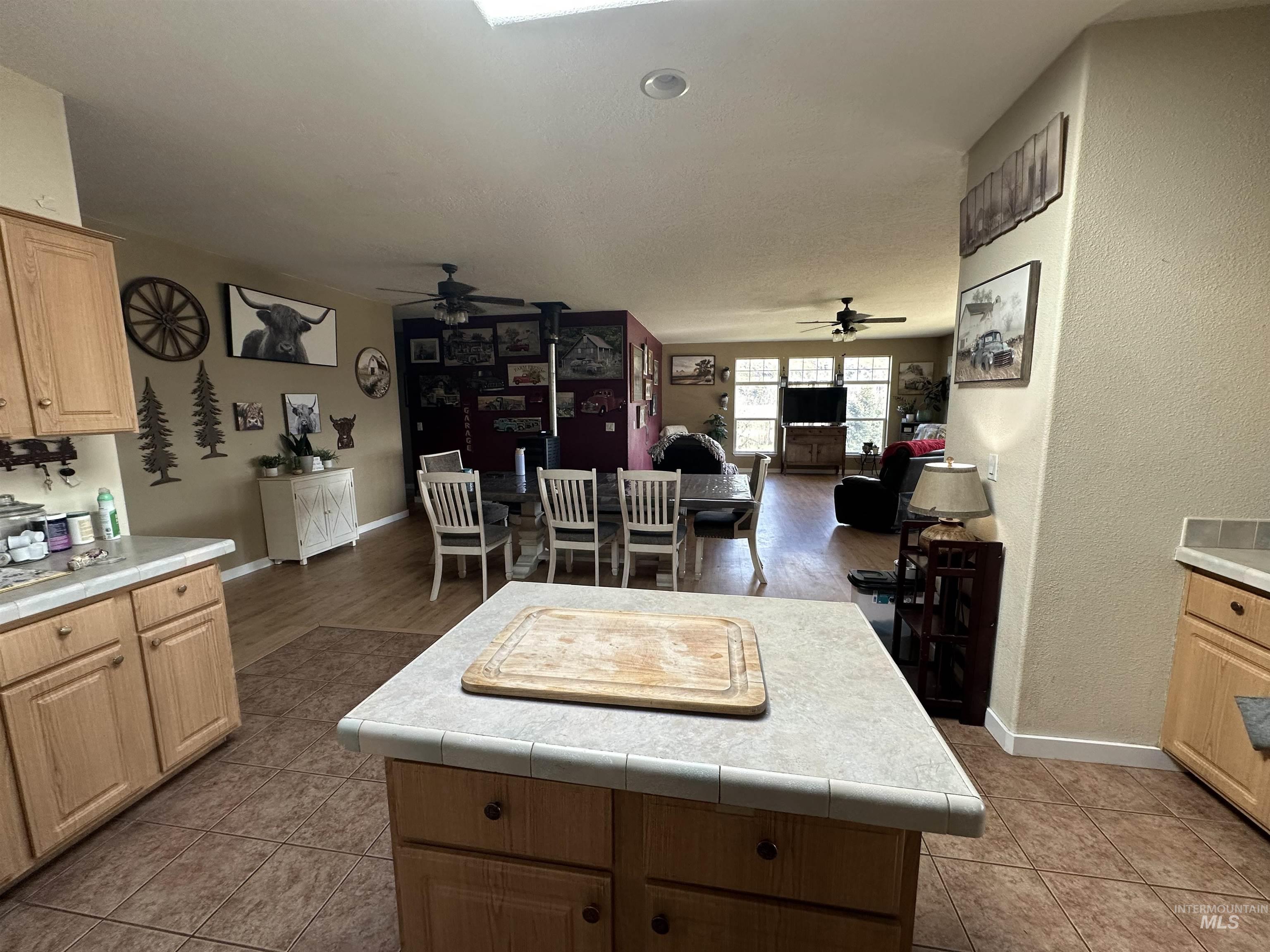 2859 Luke's Gulch Road Stites, ID 83552 - Photo 48 of 48 Kitchen featuring light wood finish cabinetry, a kitchen island, tile counters, open floor plan, and a ceiling fan