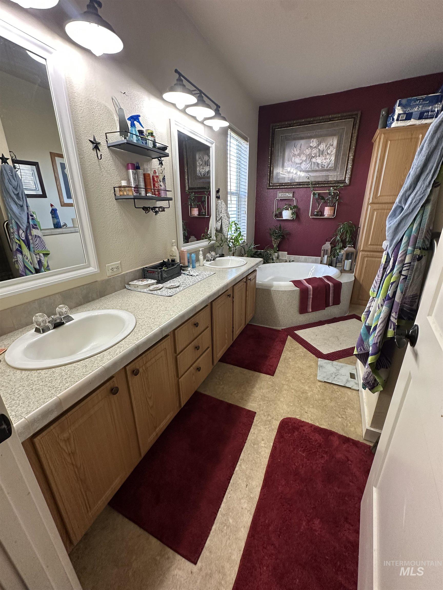 2859 Luke's Gulch Road Stites, ID 83552 - Photo 17 of 48 Bathroom featuring double vanity, a bath, and a textured wall