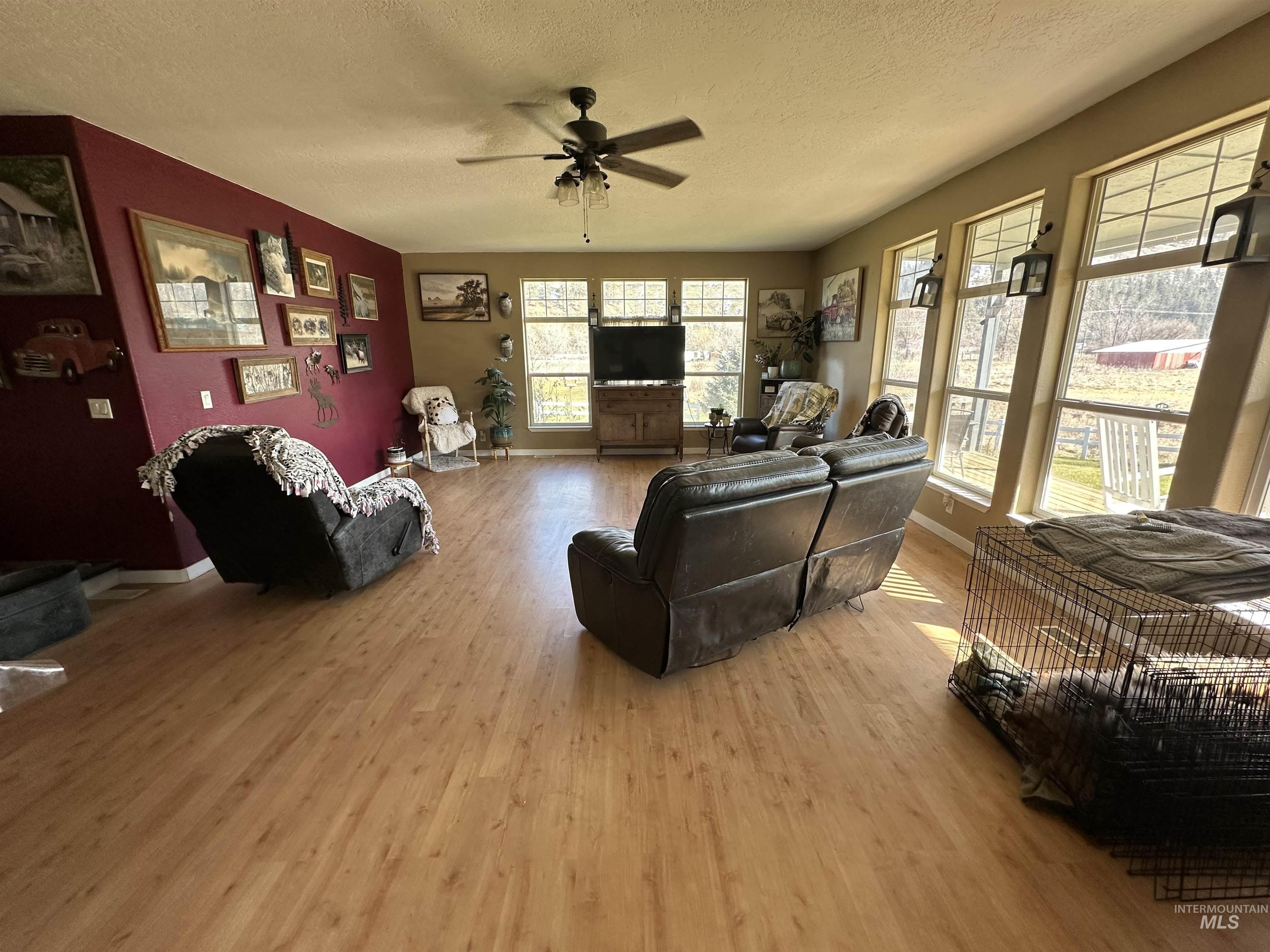 2859 Luke's Gulch Road Stites, ID 83552 - Photo 10 of 48 Living area with a textured ceiling, a ceiling fan, and light wood-style flooring