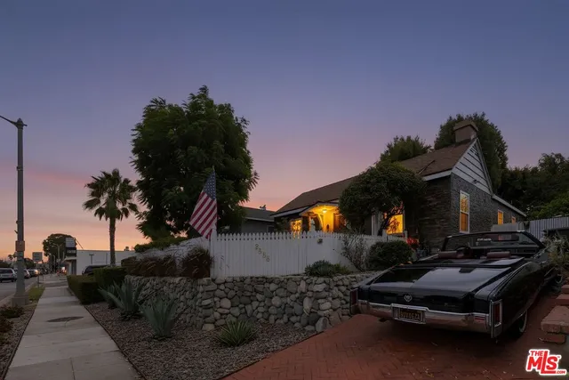 a front view of a house with sitting area and garden