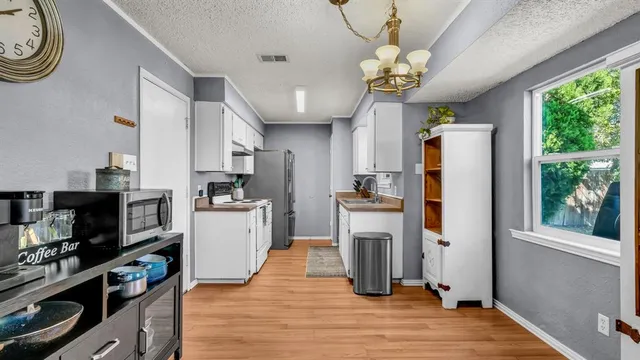 a kitchen with stainless steel appliances granite countertop a refrigerator a oven a stove and a wooden floors